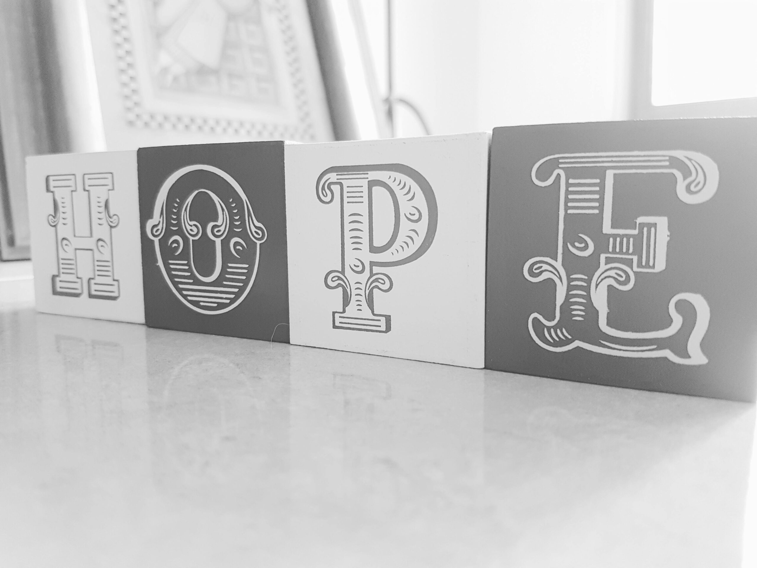 A grayscale picture of the word "hope" spelled using blocks.