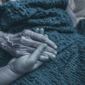 Hand gently clasping older hand